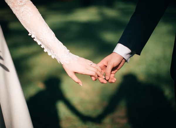 영국 전통 결혼식에서 손을 잡고 사랑을 표현하는 신랑과 신부의 클로즈업 사진