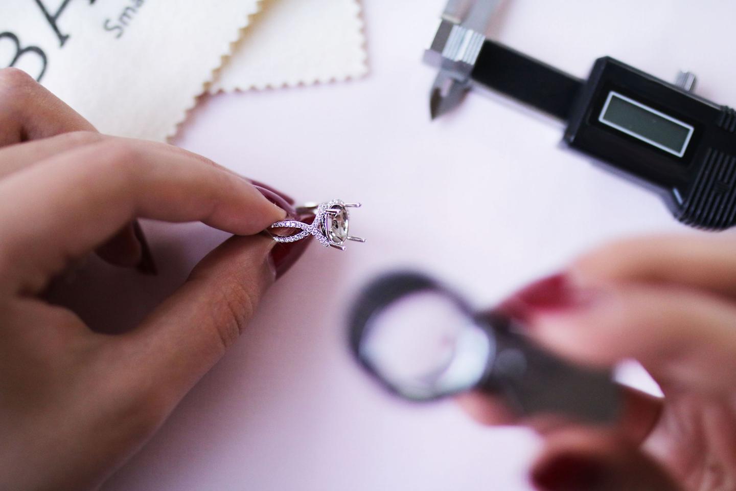 Ein Juwelier von BAUNAT  betrachtet einen Ring mit Diamanten durch die Diamantlupe