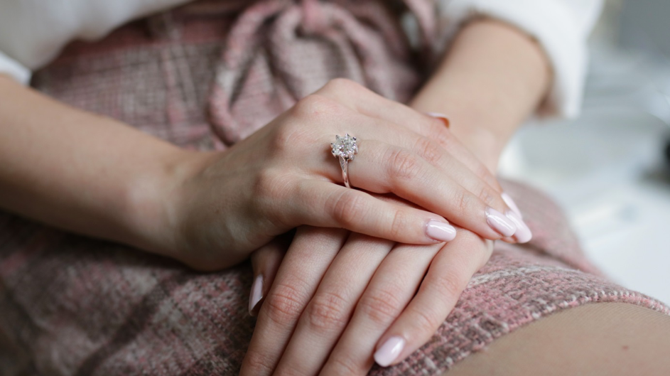 Frau mit Verlobungsring mit zartrosa Diamant