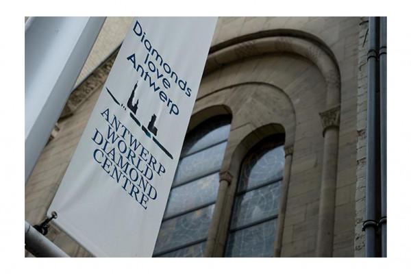 White banner for Antwerp World Diamond Centre logo on a stone building exterior