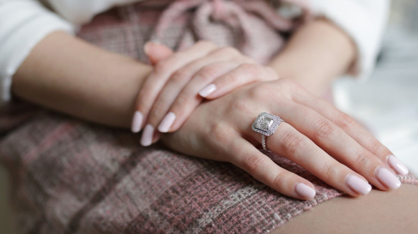 Exklusiver viereckiger Verlobungsring  - Ein exklusiver Verlobungsring mit viereckigem Diamanten im Smaragdschliff und umgebenden Diamanten, Ringschiene mit Pavé Diamanten.