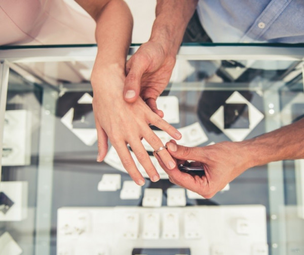 Qui porte une bague de fiançailles ? - Un homme met une bague de fiançailles en diamant à sa bien-aimée.