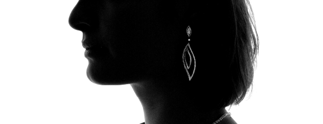 Silhouette einer Frau mit asymmetrischem langen Diamant-Ohrring aus Weißgold in blattförmigem Design