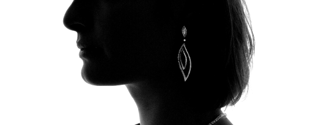 Silhouette einer Frau mit asymmetrischem Diamant-Ohrring aus Weißgold, längliches marquises Motiv mit funkelnder Pavé-Fassung