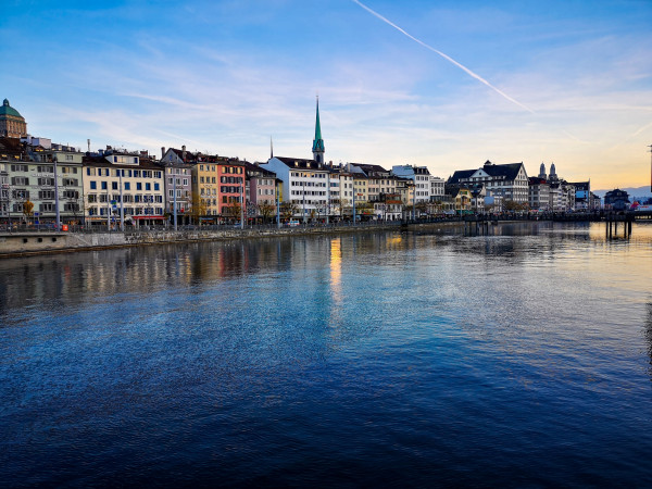 Panoramablick auf die Zürcher Altstadt am Fluss mit Kirchturm und spiegelndem Wasser