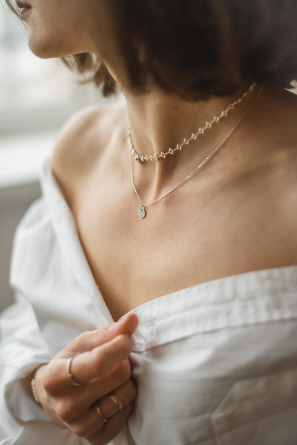Damen mit zwei filigranen Goldketten, eine mit Herzanhänger und eine mit Diamantkette