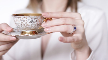 Woman drinking tea and wearing a BAUNAT diamond and sapphire ring