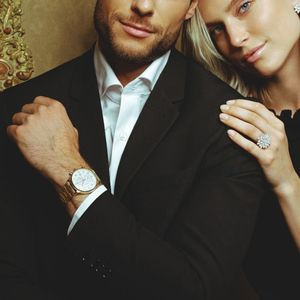 Couple élégant portant une montre en or blanc et une bague pavée de diamants, style raffiné