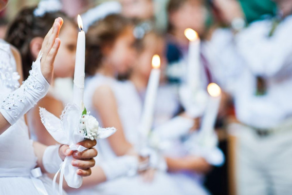 Durante el sacramento de la misa solemne de comunión, los niños reciben un collar con una cruz - BAUNAT