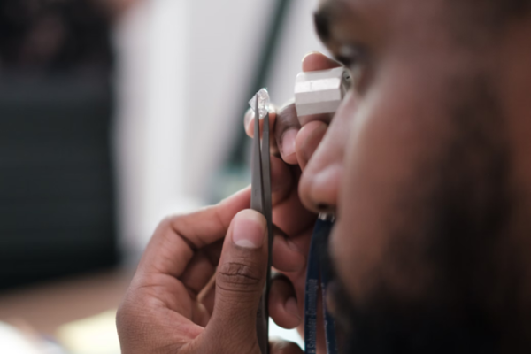 a man carefully investigating a diamond with his eyes, looking to see if he can recognize diamond treatments