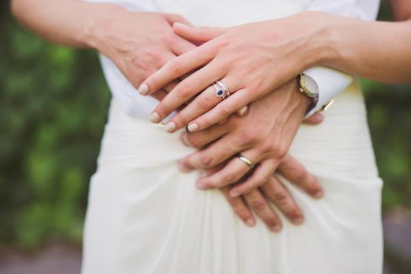 picture full of symbolism BAUNAT - close up of bride and groom's hands with wedding rings, symbolising eternal love in modern culture