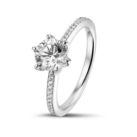 a round diamond solitaire ring with six prongs and side stones, showcasing the importance of precious stones in engagement rings