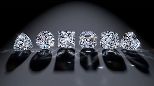 A row of various diamond cuts displayed on a sleek black background, showcasing their distinctive brilliance and elegance.