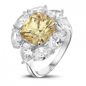 A stunning yellow diamond ring featuring a cushion cut center stone surrounded by sparkling white diamonds.