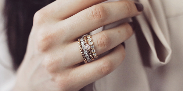 close-up van de hand van een vrouw die meerdere ringen aan een vinger draagt