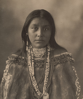 a native American woman adorned with a striking necklace, reflecting her rich cultural background and identity