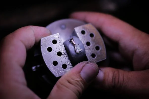 Un professionnel produit un bijou en diamant de BAUNAT. 