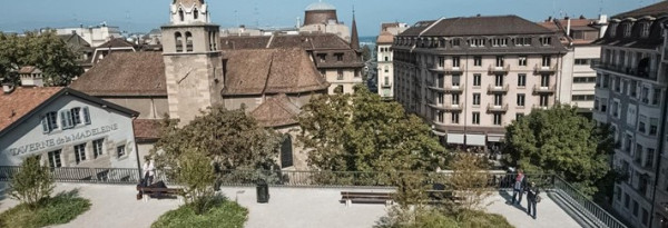 Schilderachtig stadsgezicht van Genève met een kerk en een klokkentoren, waarbij de Baunat-showroom charme toevoegt aan het tafereel.