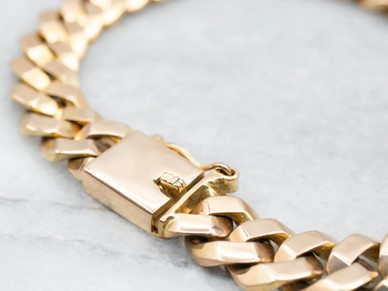 Ein goldenes Kettenarmband mit einem sicheren Box-Verschluss, elegant gestaltet für einen raffinierten Look.
