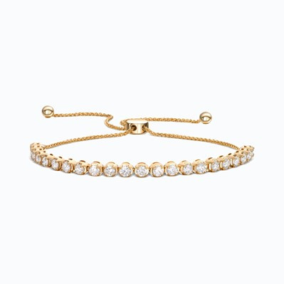 Ein goldenes Armband, das mit Diamanten verziert ist, mit einem sicheren Bolo-Verschluss für verstellbare Passform und Eleganz