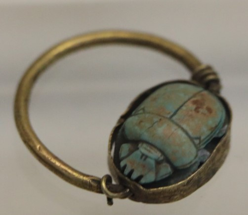 Une bague scarabée égyptienne ornée d'une pierre turquoise vibrante, symbolisant la protection et la transformation dans la culture ancienne.