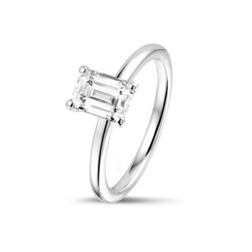 Un diamant taille émeraude élégamment exposé sur une surface blanche immaculée, mettant en valeur sa clarté et sa brillance