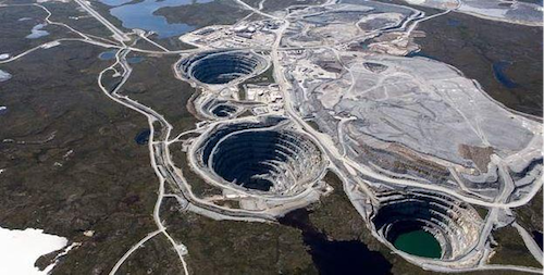 Bovengrondse opname van een grote open diamantmijn, waarbij de ingewikkelde lagen en het omringende natuurlijke terrein worden onthuld