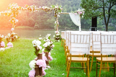 Stühle und Blumen bei einer malerischen Hochzeitszeremonie im Freien im Sommer