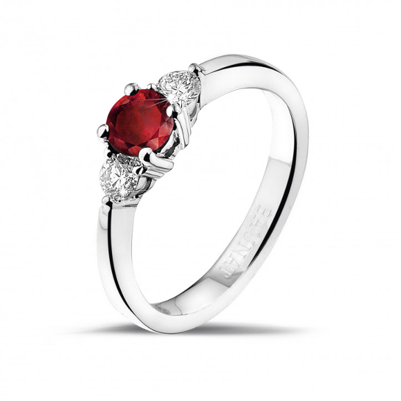 trilogie ring in witgoud met een centrale robijn geflankeerd door 2 ronde geslepen, kleinere witte diamanten
