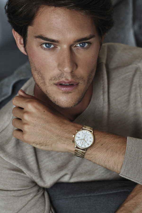 Een man die een gouden horloge van BAUNAT draagt