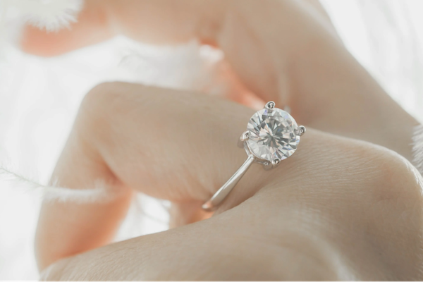 La main d'une femme tient gracieusement une bague en diamant étincelante, apportant la bonne fortune