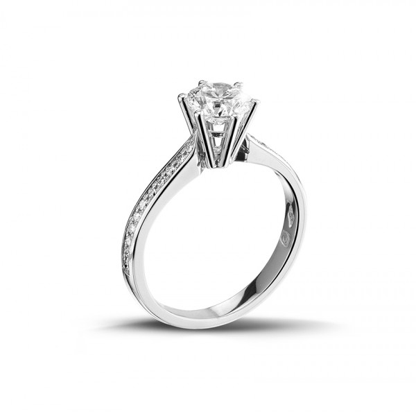 een witgouden briljant geslepen diamanten ring met zijdiamanten op een witte achtergrond