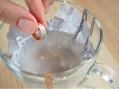 Waschen von Schmuckstücken aus Rosé- und Weissgold (Halsketten und Ringe) in einer Schüssel mit Seifenwasser, nachdem sie schädlichen Chemikalien oder Salzwasser ausgesetzt waren.