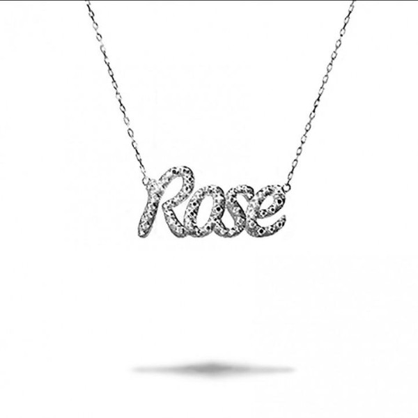 Un pendente in oro bianco con pavé di diamanti con la scritta 