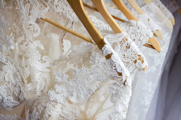 Abiti da sposa bianchi su appendiabiti in legno - abito da sposa - negozio 