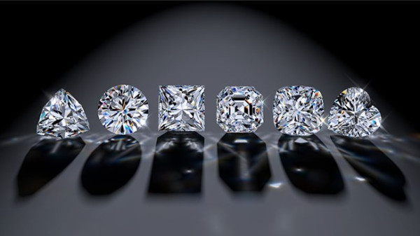 Una fila di diamanti con tagli diversi esposti su un elegante sfondo nero, che ne mettono in risalto la brillantezza e l'eleganza distintive.