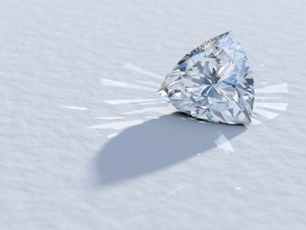 Un diamante dal taglio trilione brilla su una superficie bianca immacolata, mettendo in mostra la sua brillantezza e le sue sfaccettature intricate.