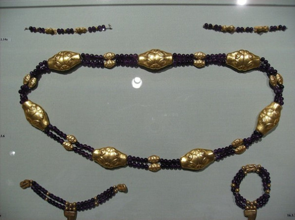 Una cavigliera con perline dorate e nere, dal design elegante