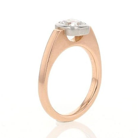Un anello di fidanzamento con un diamante centrale incastonato in un'elegante montatura a castone aperto, che ne esalta la brillantezza e il design. 
