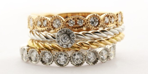 Quattro anelli di fidanzamento con diamanti, tra cui un delicato anello a fascia sottile, che mettono in risalto la squisita maestria artigianale.