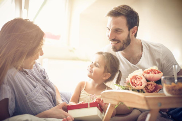Daughter giving her mother a gift for Mother's Day. Perhaps even a bracelet. - BAUNAT