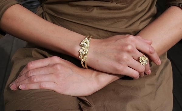 Image of a woman showcasing a stunning gold bracelet adorned with diamonds and a matching ring