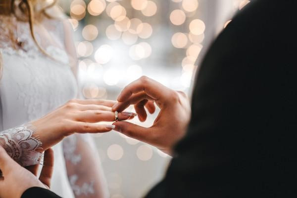 BAUNAT - a groom placing a ring on the bride's ring finger during a modern wedding ceremony