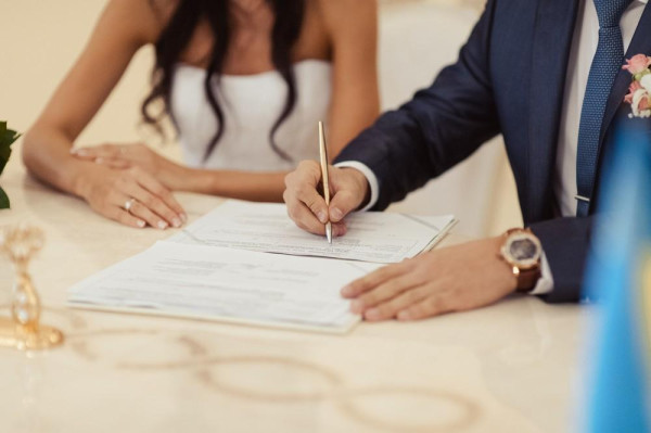 BAUNAT - Couple signing the marriage certificate. Getting married abroad is also legal. – BAUNAT