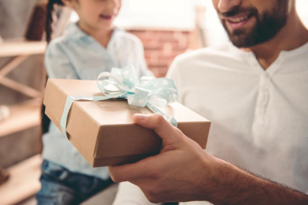 A man gets a Father's Day gift from a child. Choose an original Father's Day gift from jeweller BAUNAT