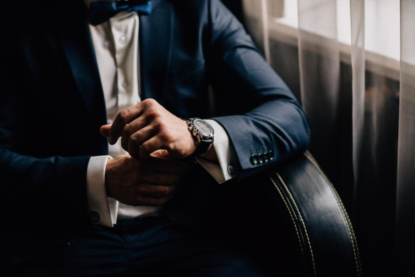 man wearing a tailor-made suit and a stylish watch on his wrist