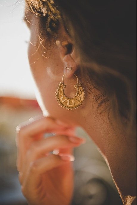 eine Frau mit auffälligen Gold-Creolen, die die Eleganz des traditionellen griechischen Schmucks repräsentiert.