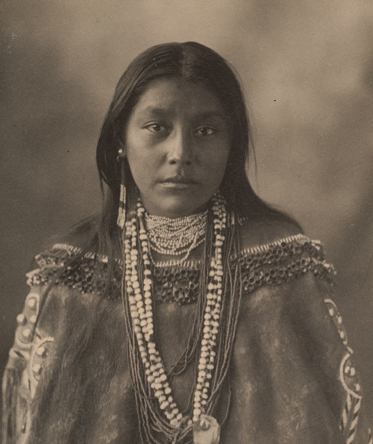 eine US-indianische Frau, die mit einer auffälligen Halskette geschmückt ist, die ihren reichen kulturellen Hintergrund und ihre Identität widerspiegelt