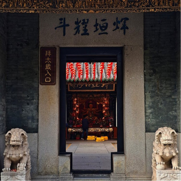 Ein chinesischer Tempel ragt empor, mit einer majestätischen Löwenstatue, die den Eingang bewacht und die traditionelle chinesische Kultur zeigt. 