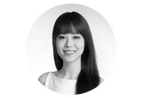 白いトップスを着た女性のモノクロのポートレートで、首元に小ぶりなダイヤモンドネックレスを着用している